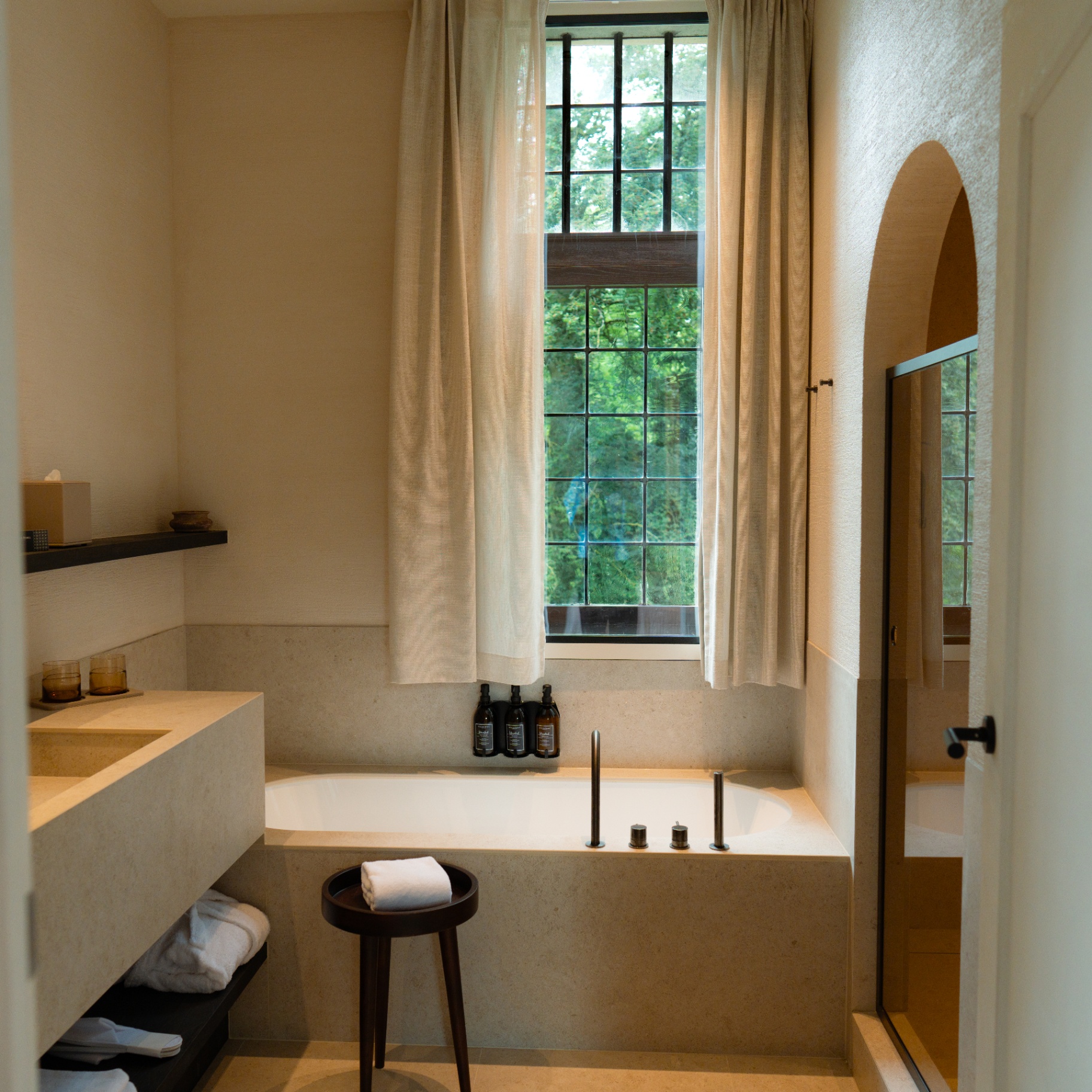 Sfeervolle badkamer met natuurlijk licht in een gastenkamer van Priorij Corsendonk