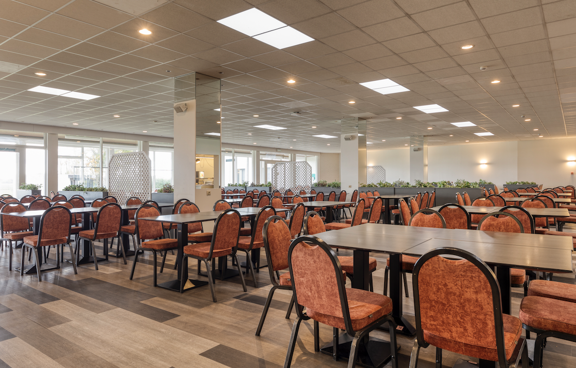 Ruime restaurantzaal met warme tinten bij Corsendonk Duinse Polders